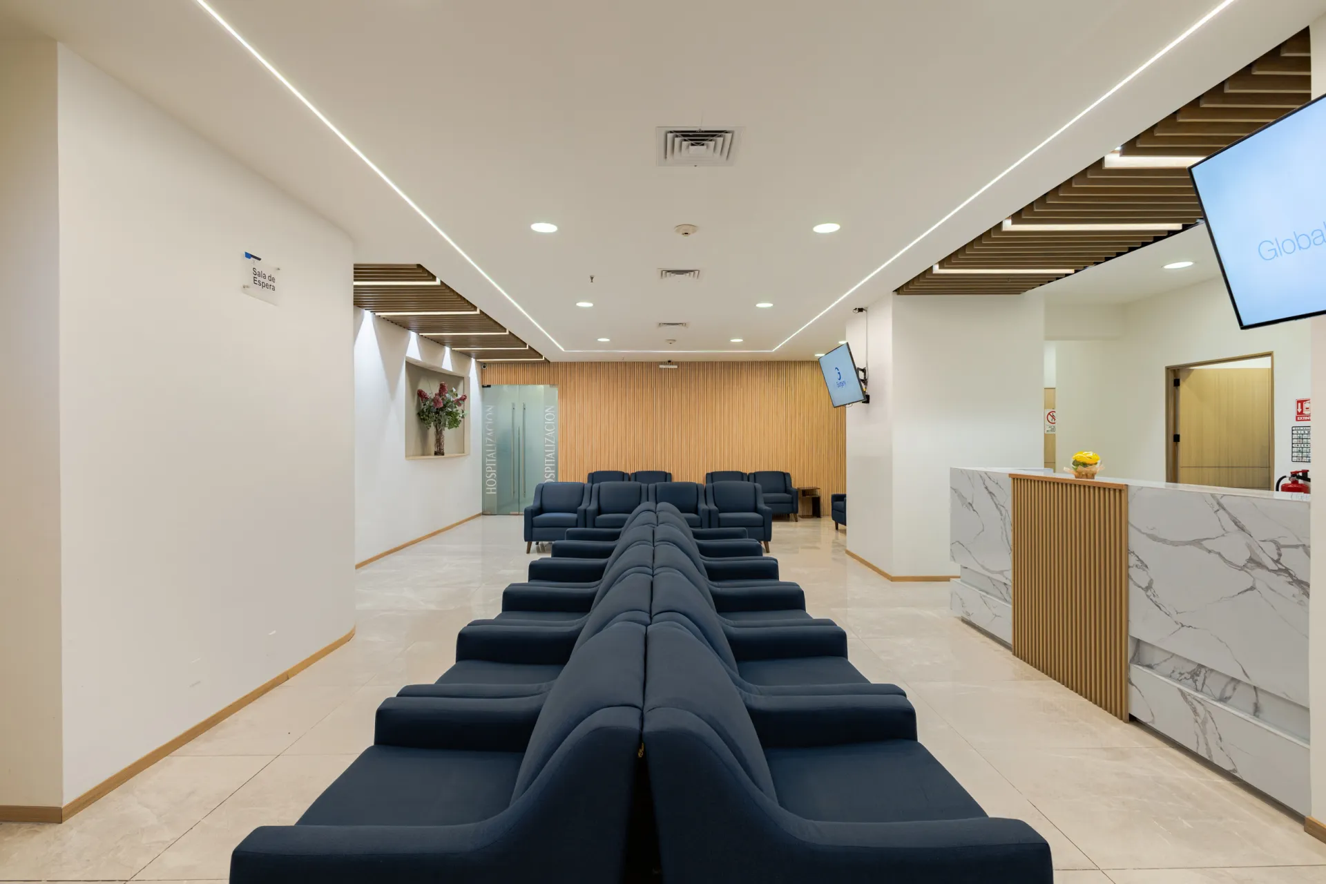 Recepción con el logotipo de Global Surgery Center en pantalla y mostrador de mármol